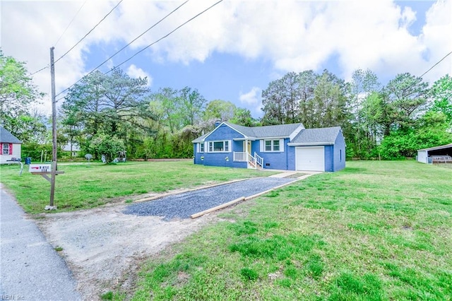 view of front of property featuring a front yard, driveway, and an attached garage