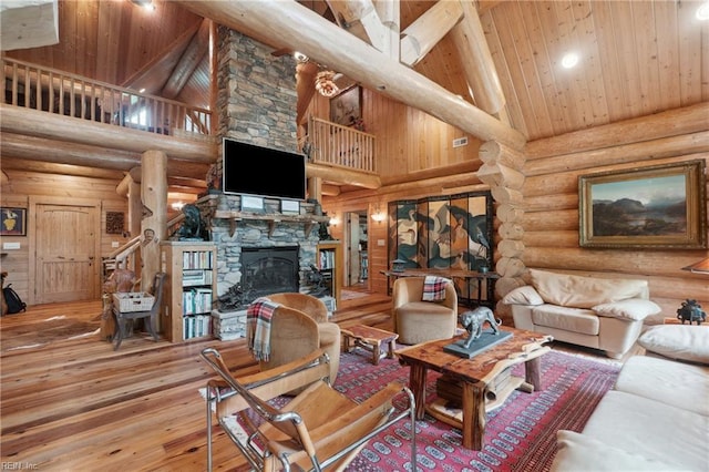 living room with a stone fireplace, hardwood / wood-style floors, beam ceiling, high vaulted ceiling, and wood ceiling