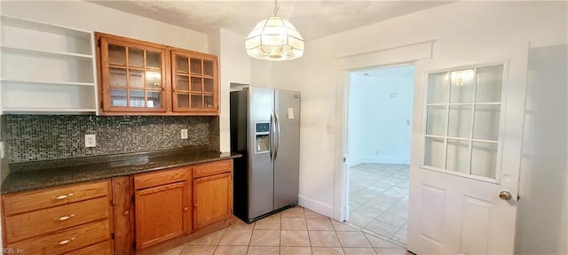 kitchen featuring stainless steel fridge with ice dispenser, brown cabinetry, open shelves, a chandelier, and dark countertops