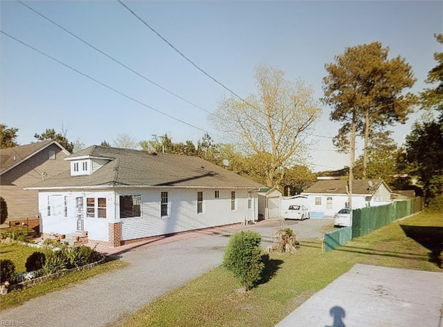 view of front of home with driveway, a front yard, and fence