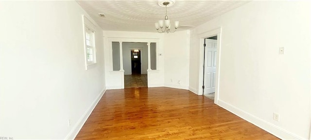corridor with baseboards, light wood-type flooring, and an inviting chandelier