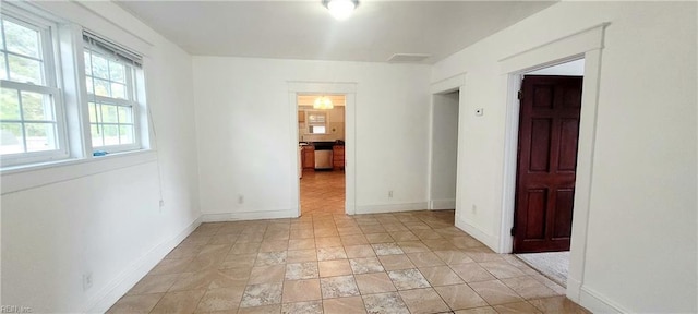 unfurnished room with baseboards