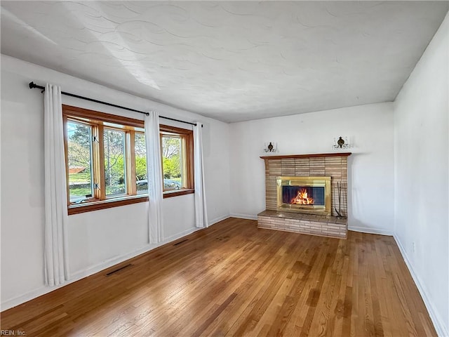 1279 Old Buckroe Rd, Hampton, VA 23663 - unfurnished living room with baseboards, a fireplace, wood-type flooring, and visible vents