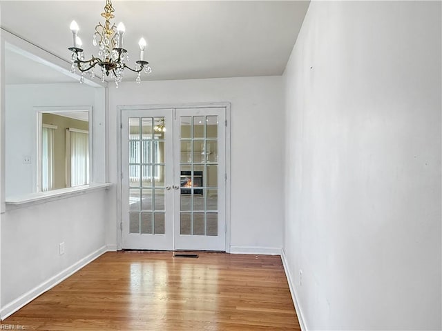 1279 Old Buckroe Rd, Hampton, VA 23663 - unfurnished dining area featuring french doors, baseboards, a chandelier, and wood finished floors