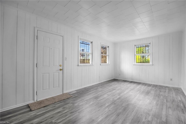 foyer entrance featuring visible vents, baseboards, and wood finished floors