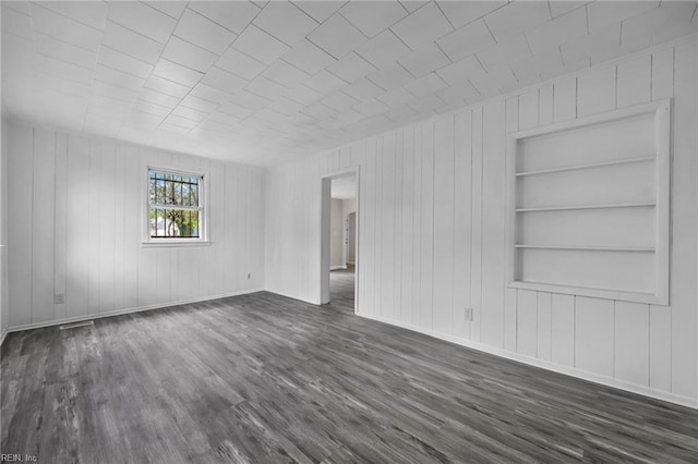 unfurnished room with built in features, baseboards, and dark wood finished floors