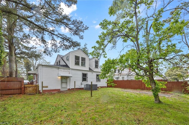 back of property featuring a yard, fence, and central AC