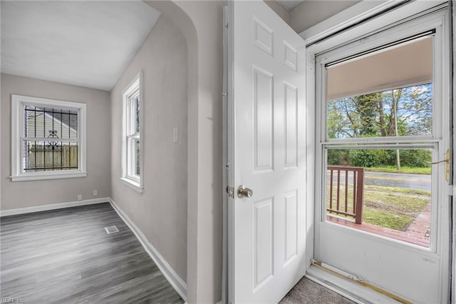 interior space with wood finished floors, baseboards, visible vents, and a wealth of natural light