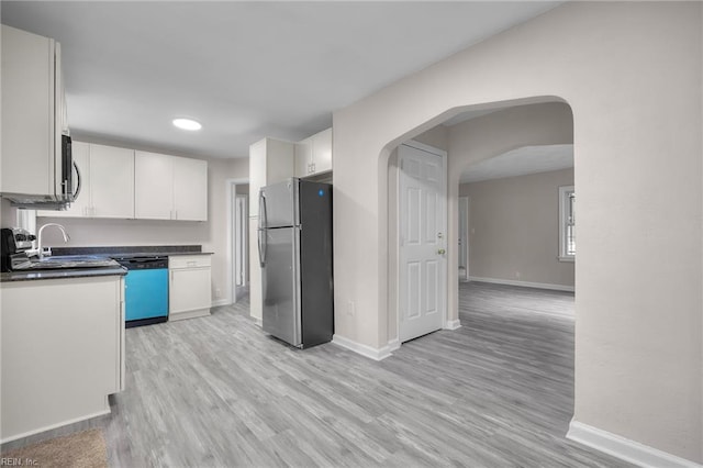 kitchen with stainless steel appliances, light wood-type flooring, baseboards, and dark countertops