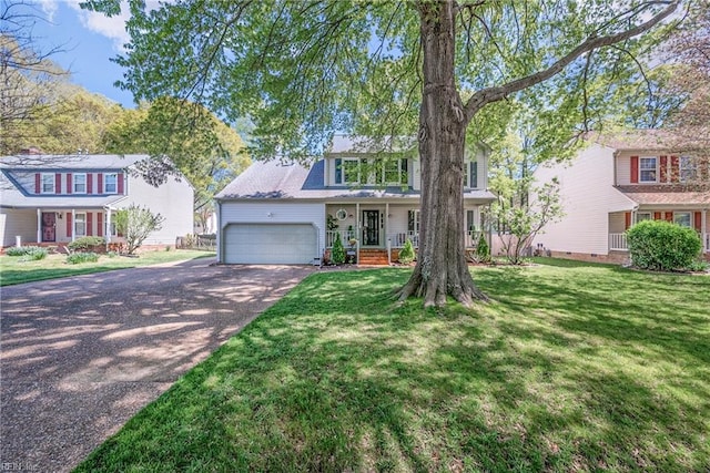 943 Tabb Lakes Dr, Yorktown, VA 23693 - view of front of property with aphalt driveway, a porch, a front lawn, and an attached garage