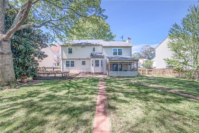 943 Tabb Lakes Dr, Yorktown, VA 23693 - rear view of house featuring a chimney, a sunroom, a wooden deck, a yard, and fence