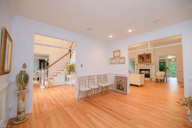 living room featuring crown molding, wood finished floors, and stairway