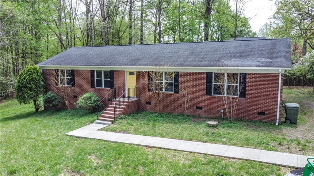 ranch-style home with crawl space, roof with shingles, a front lawn, and brick siding