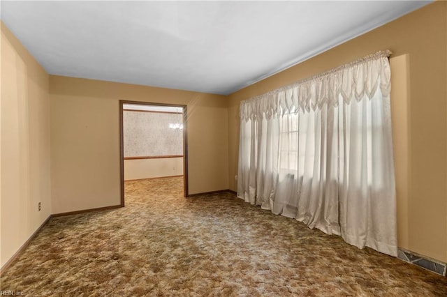 empty room with visible vents, baseboards, and carpet floors