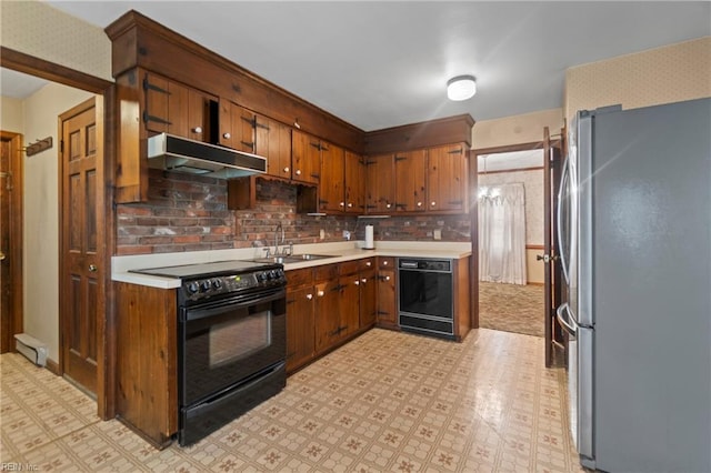 kitchen with under cabinet range hood, a sink, black appliances, and light floors
