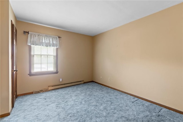 carpeted spare room with a baseboard heating unit and baseboards