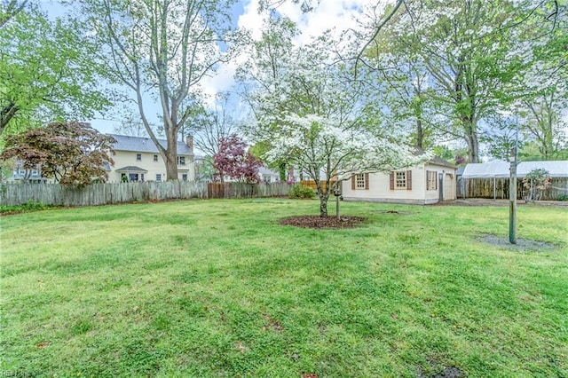 view of yard featuring a fenced backyard and an outbuilding