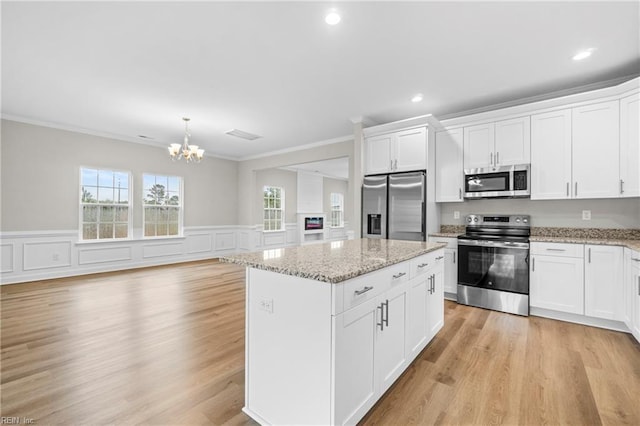 kitchen featuring a chandelier, white cabinetry, crown molding, a kitchen island, and appliances with stainless steel finishes