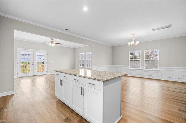 kitchen with open floor plan, a kitchen island, visible vents, and a wealth of natural light