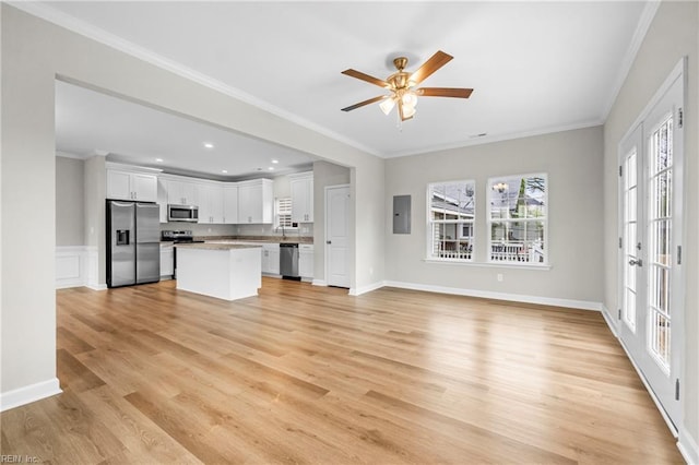 unfurnished living room featuring light wood-style flooring, ceiling fan, electric panel, and crown molding