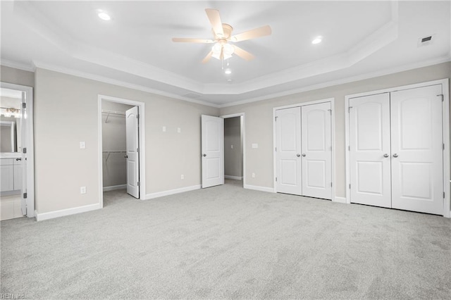 unfurnished bedroom featuring crown molding, ensuite bath, recessed lighting, carpet flooring, and a raised ceiling