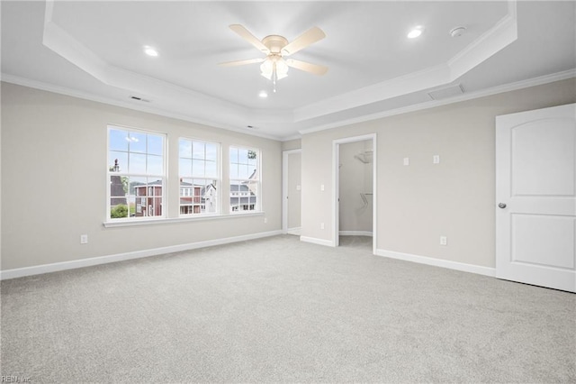 unfurnished bedroom with baseboards, crown molding, a tray ceiling, carpet floors, and recessed lighting