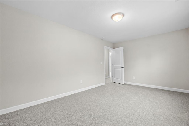 spare room featuring baseboards and carpet