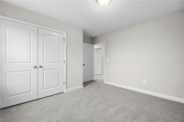 unfurnished bedroom featuring a closet, carpet flooring, and baseboards