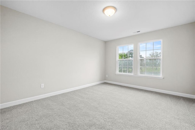 spare room featuring carpet flooring, baseboards, and visible vents