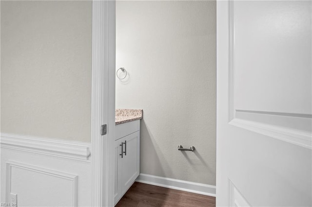 bathroom with wood finished floors, vanity, and baseboards