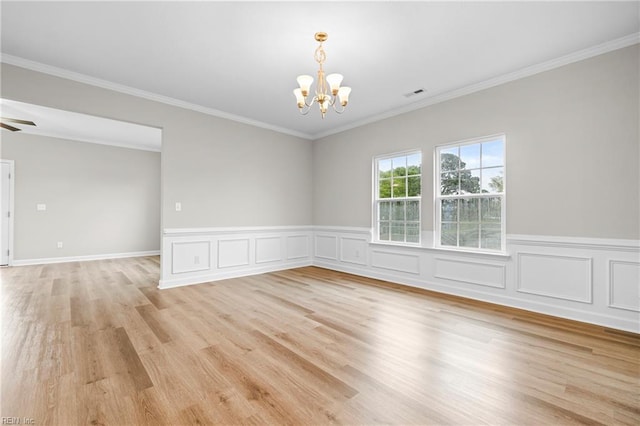 empty room with ornamental molding, visible vents, light wood-type flooring, and wainscoting