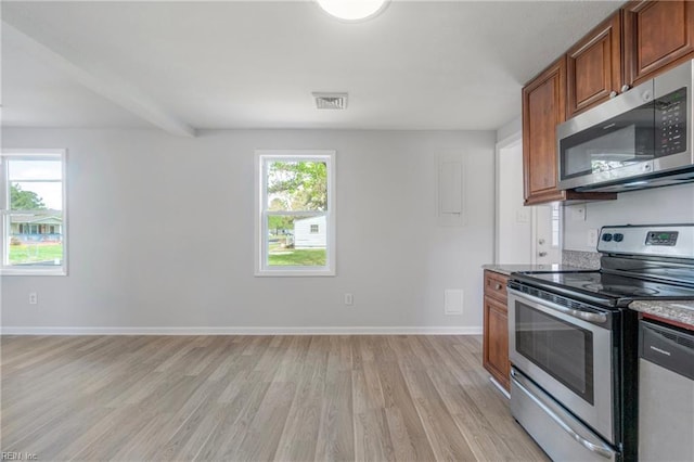 kitchen featuring visible vents, stainless steel appliances, brown cabinets, light wood finished floors, and baseboards