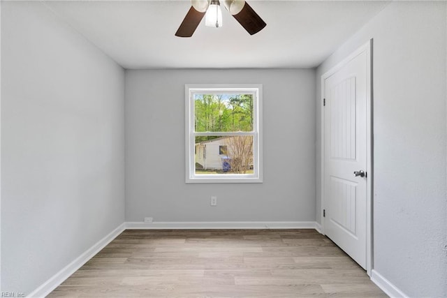 unfurnished room featuring ceiling fan, light wood finished floors, and baseboards