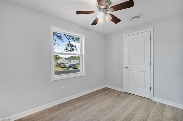 empty room with light wood finished floors, visible vents, baseboards, and ceiling fan