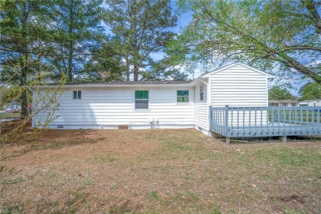 back of property featuring a deck, a lawn, and crawl space