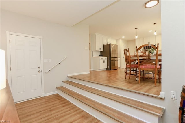 entryway with light wood-style flooring, baseboards, stairway, and recessed lighting