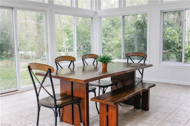 sunroom / solarium featuring tile patterned floors and baseboards