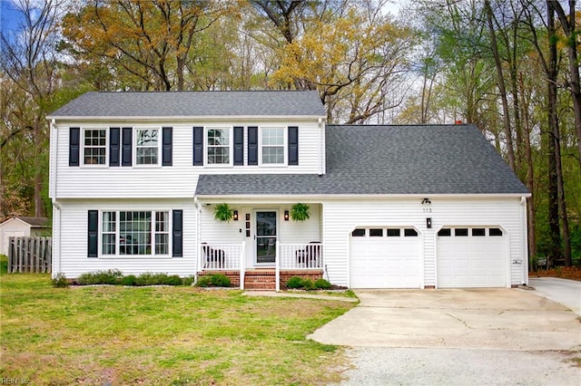 view of front of house with a garage, a front yard, concrete driveway, and covered porch