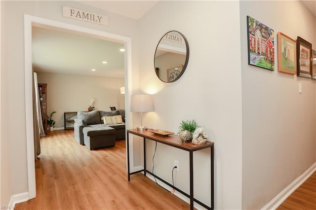 hall with baseboards, light wood-type flooring, and recessed lighting