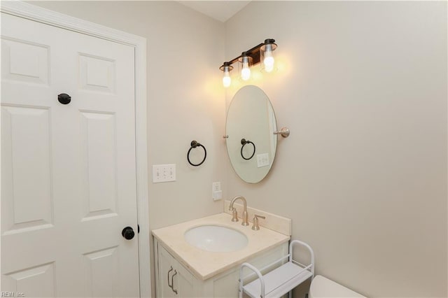 half bathroom featuring vanity and toilet