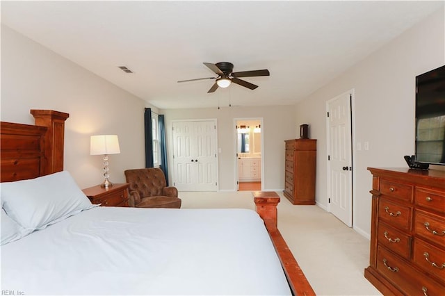 bedroom featuring baseboards, light carpet, ensuite bath, a ceiling fan, and visible vents