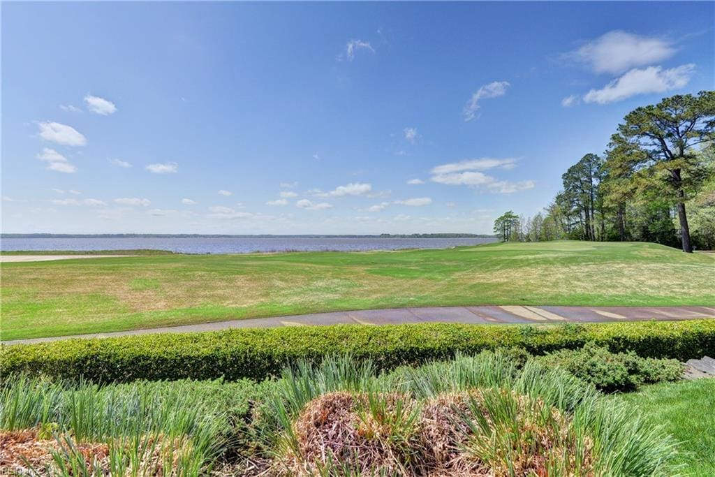 view of community featuring a water view, golf course view, and a yard