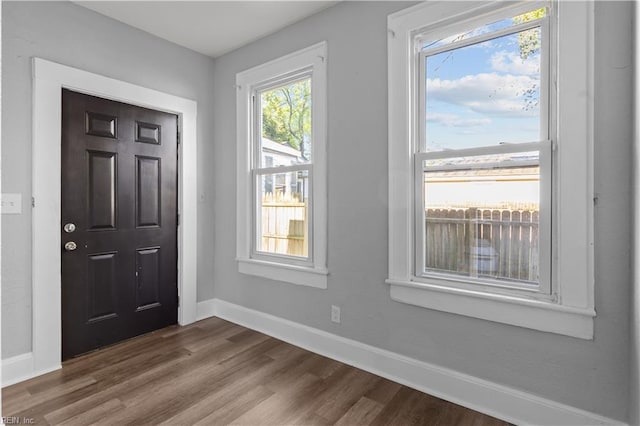 entryway with dark wood-type flooring and baseboards