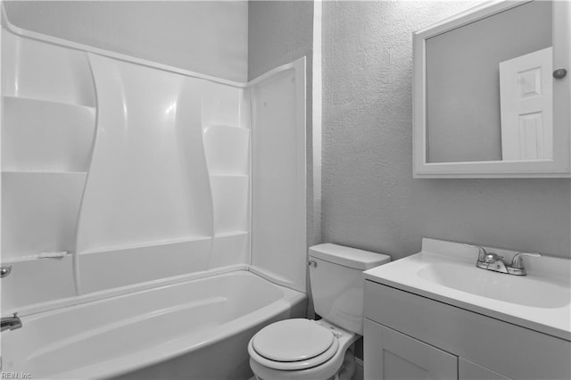 bathroom featuring toilet, a textured wall, shower / washtub combination, and vanity