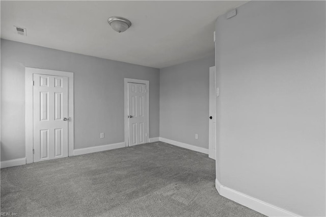 empty room featuring visible vents, baseboards, and carpet flooring
