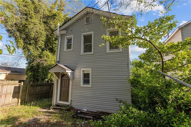 rear view of property featuring fence