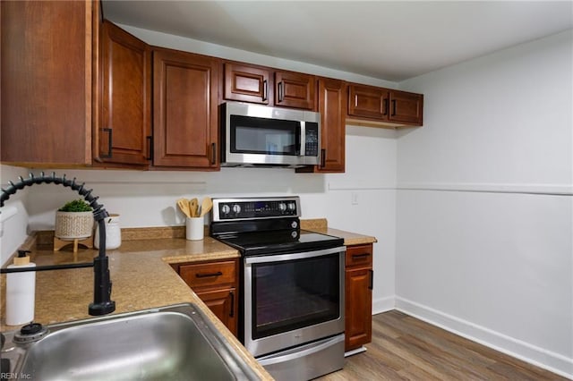 139 Ash Ave, Newport News, VA 23607 - kitchen with light wood-type flooring, baseboards, light countertops, stainless steel appliances, and a sink