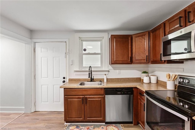 139 Ash Ave, Newport News, VA 23607 - kitchen featuring a sink, light countertops, light wood-style floors, brown cabinetry, and stainless steel appliances