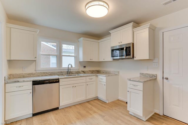 1793 Old Buckroe Rd, Hampton, VA 23664 - kitchen with light wood-style flooring, white cabinets, visible vents, stainless steel appliances, and a sink