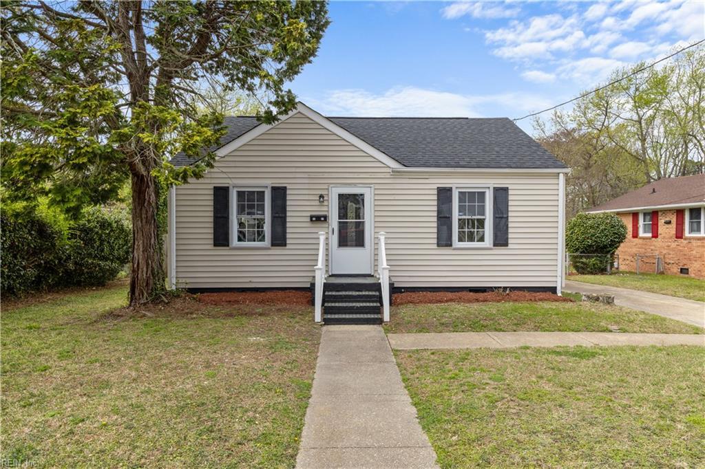 bungalow-style home with a shingled roof and a front yard